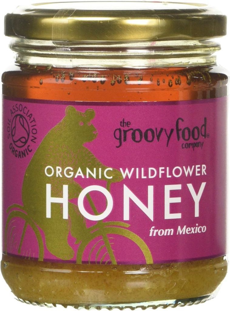 Jar of The Groovy Food Company organic wildflower honey from Mexico with purple label featuring a bear on a bike