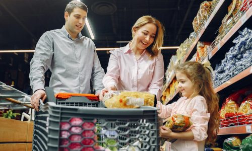 A joyful family of three shopping together in a supermarket, creating a memorable experience.